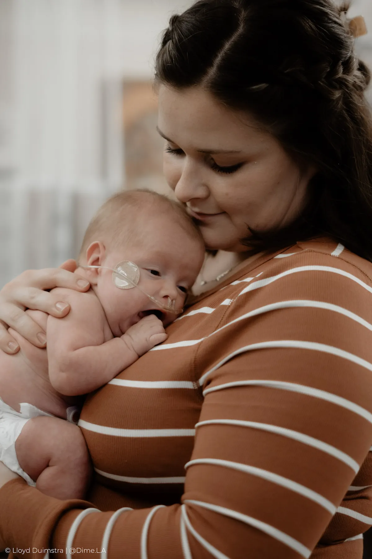 Mom cradling her newborn close, NICU documentary photography