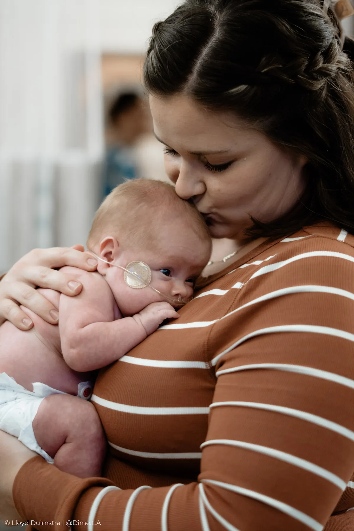 Mom kissing her newborn’s head in the NICU