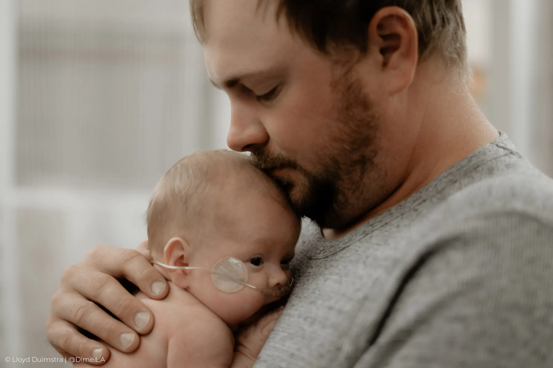 Dad holding his newborn son close in the NICU
