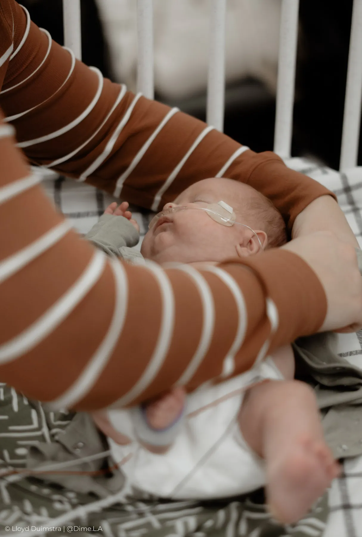 Parents leaning over the crib together in the NICU
