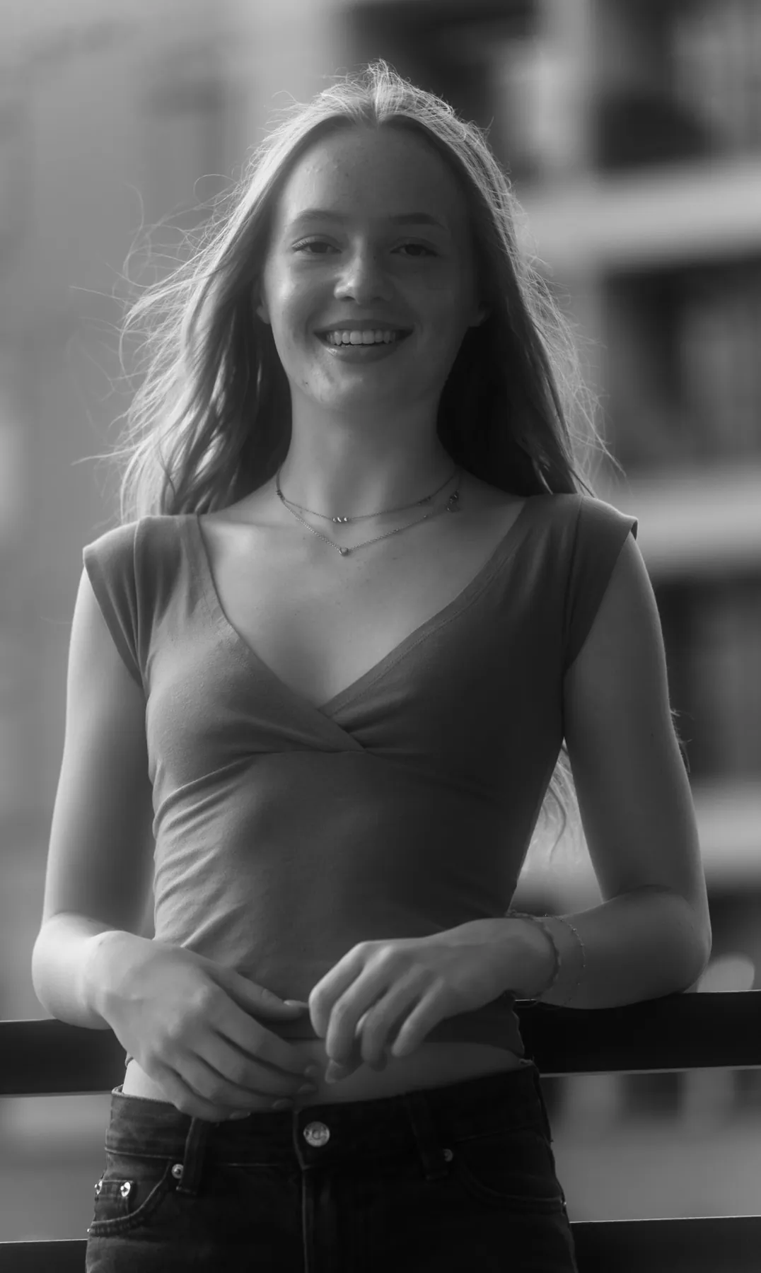 Black and white candid of Scout laughing, hair blowing across the frame