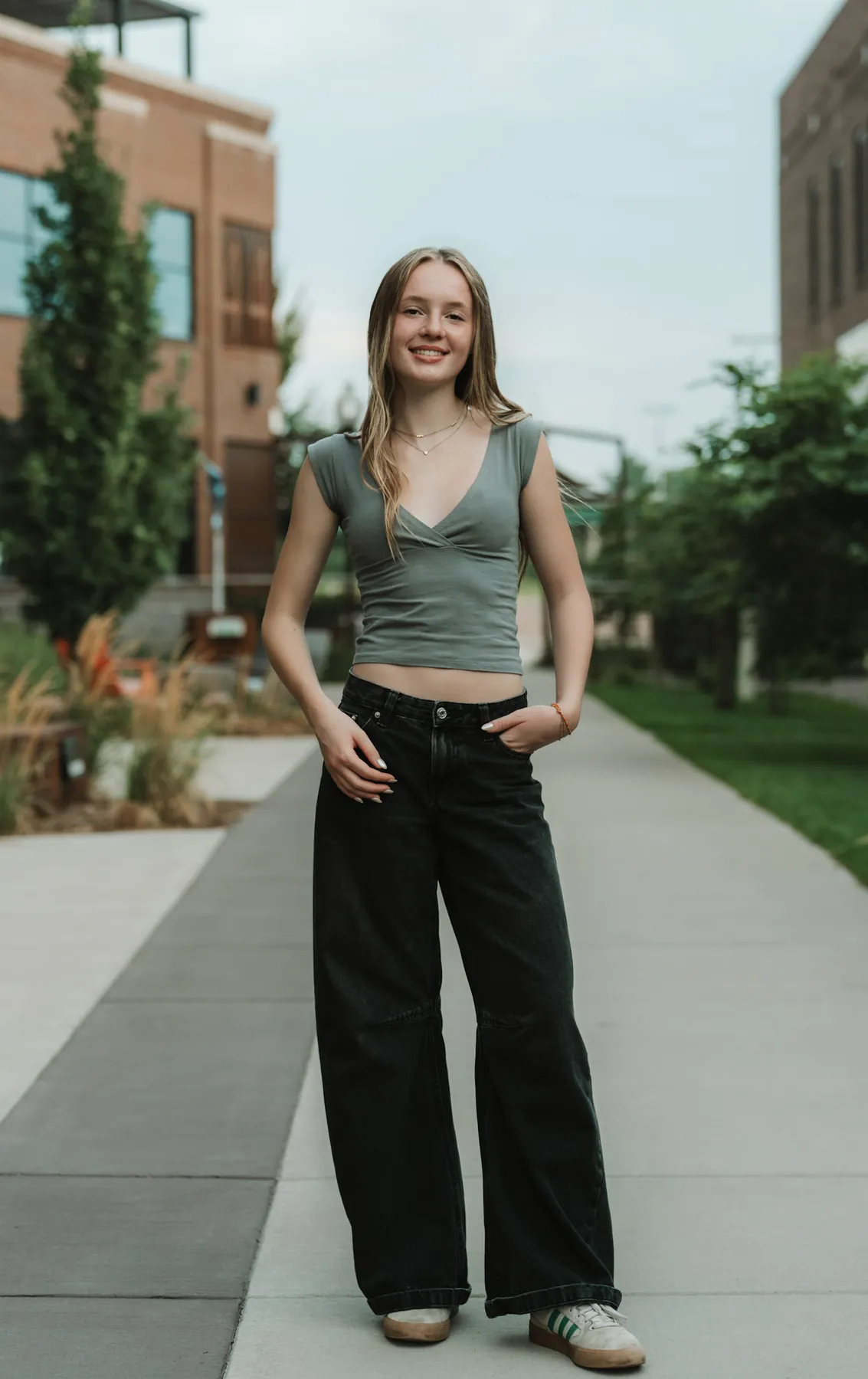 Full length senior portrait of Scout on a downtown Sioux Falls sidewalk