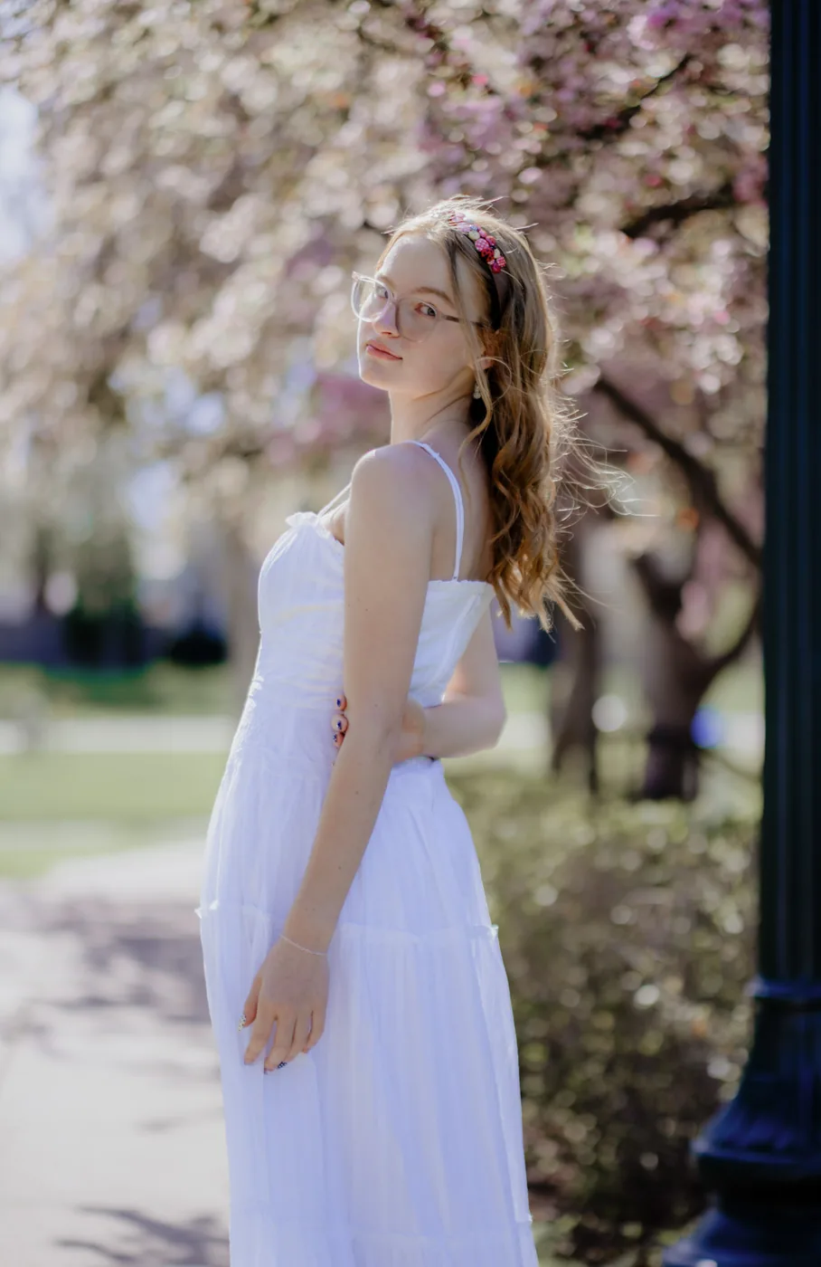 Syd Patzwald senior portrait looking back under blossom branches