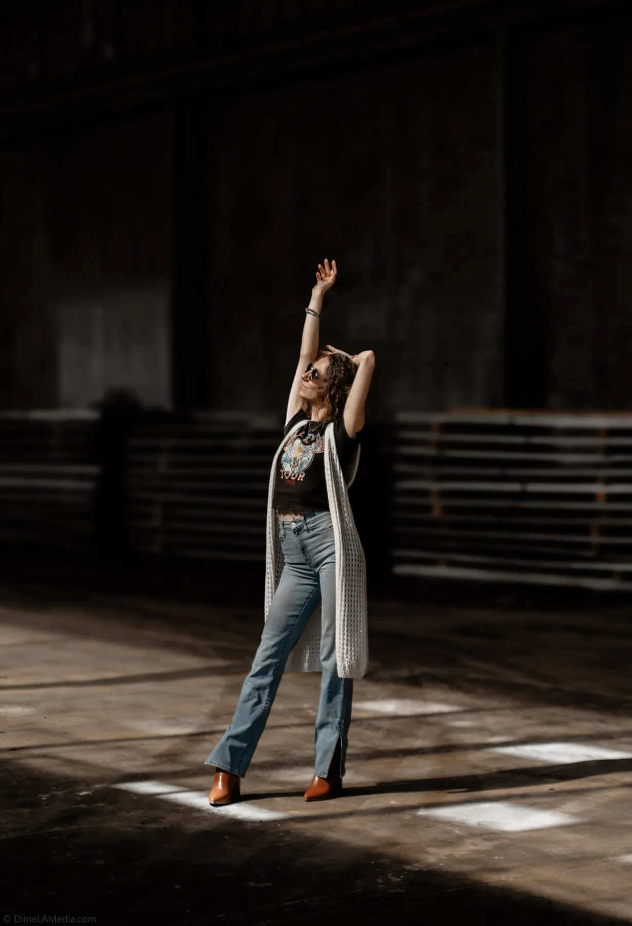Woman reaching into a shaft of warehouse sunlight