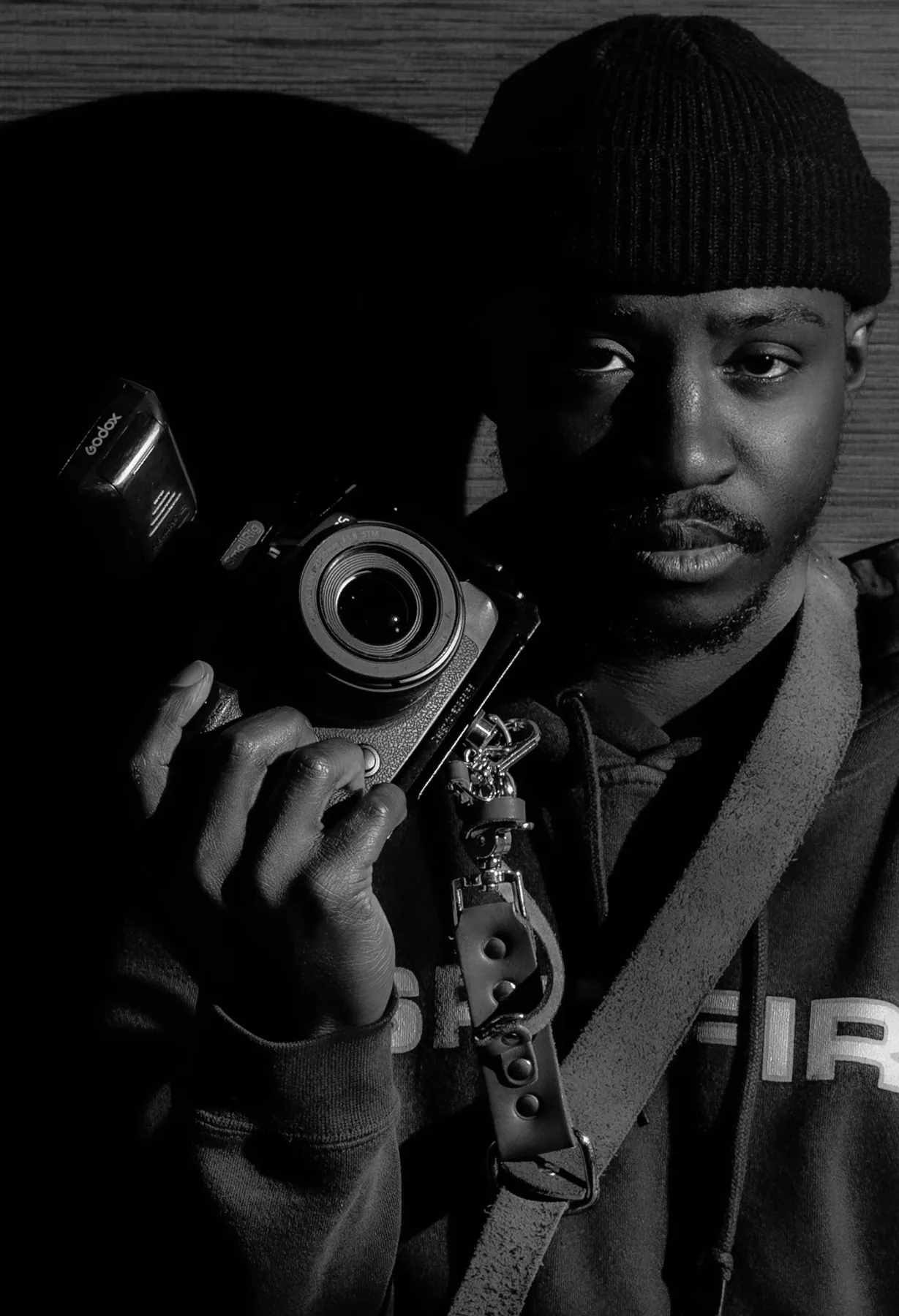 Black and white portrait of a photographer holding his film camera