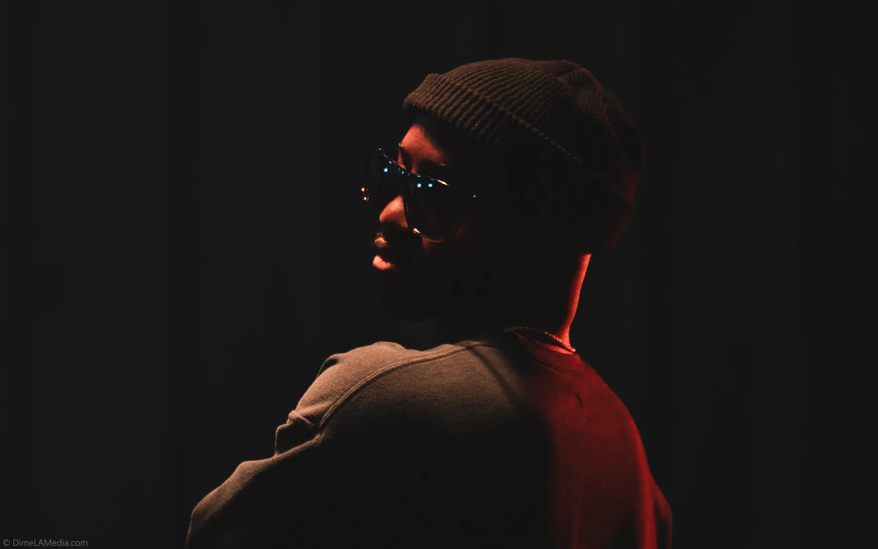 Red-lit studio profile against a dark backdrop