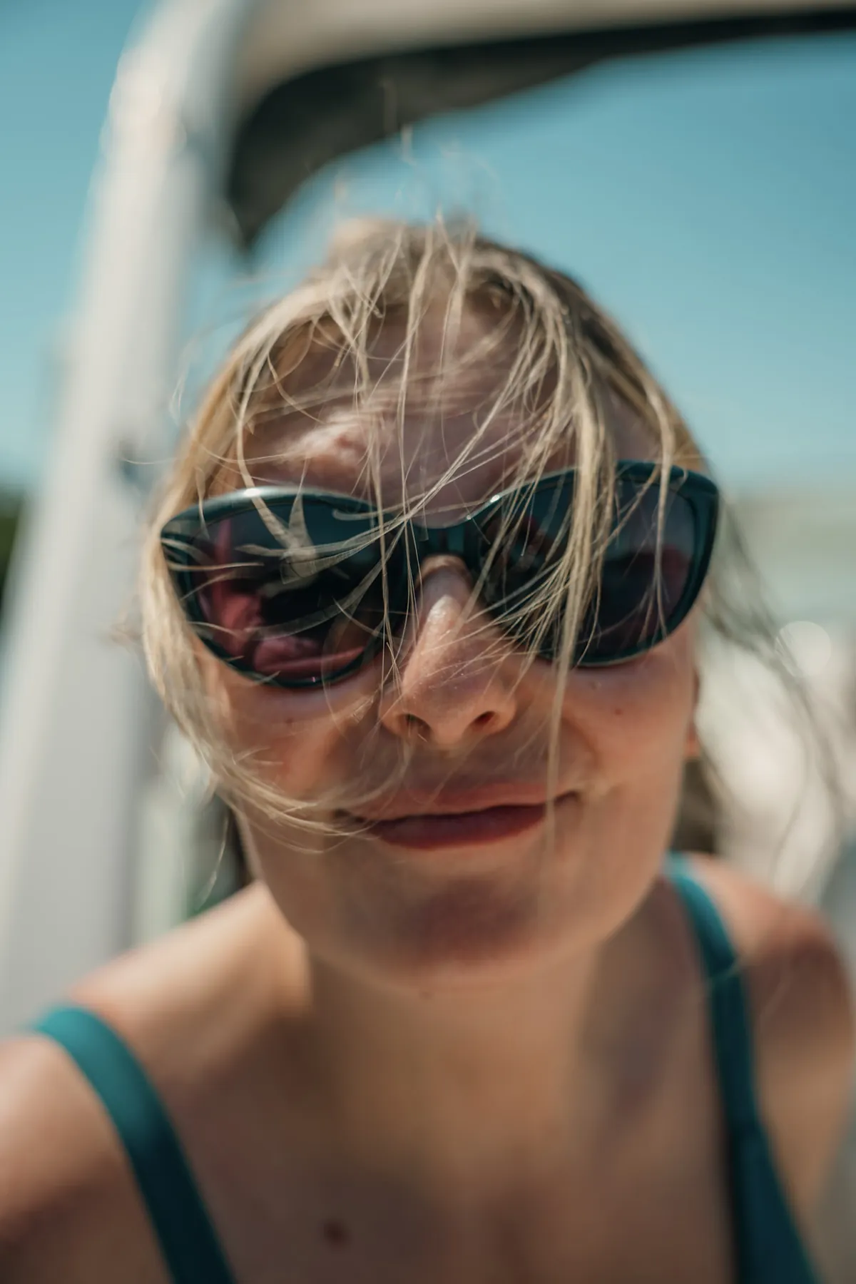 Windblown close-up portrait in sunglasses out on the water
