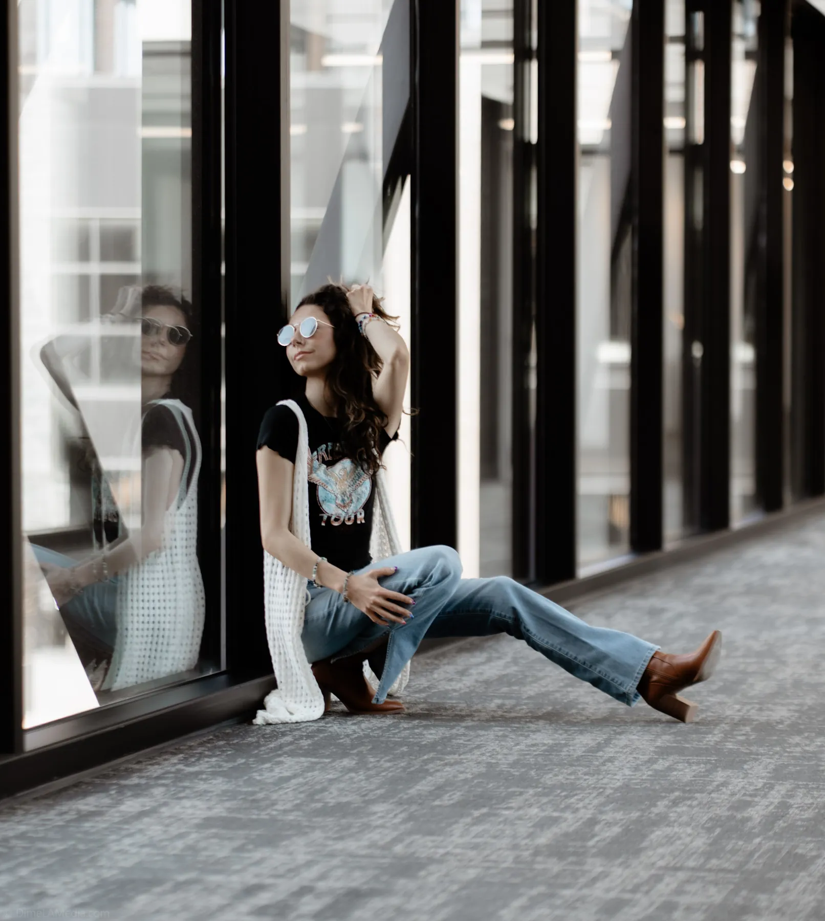 Black and white portrait along a glass corridor downtown