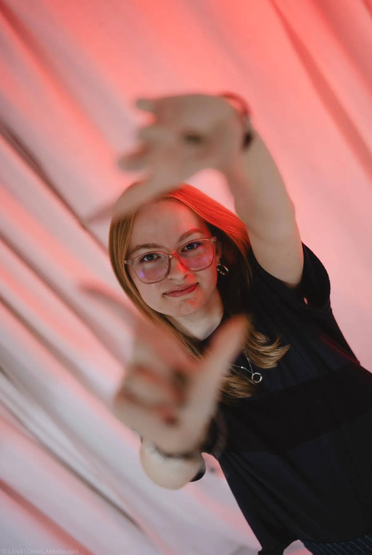 Syd Patzwald reaching toward the camera under red studio light