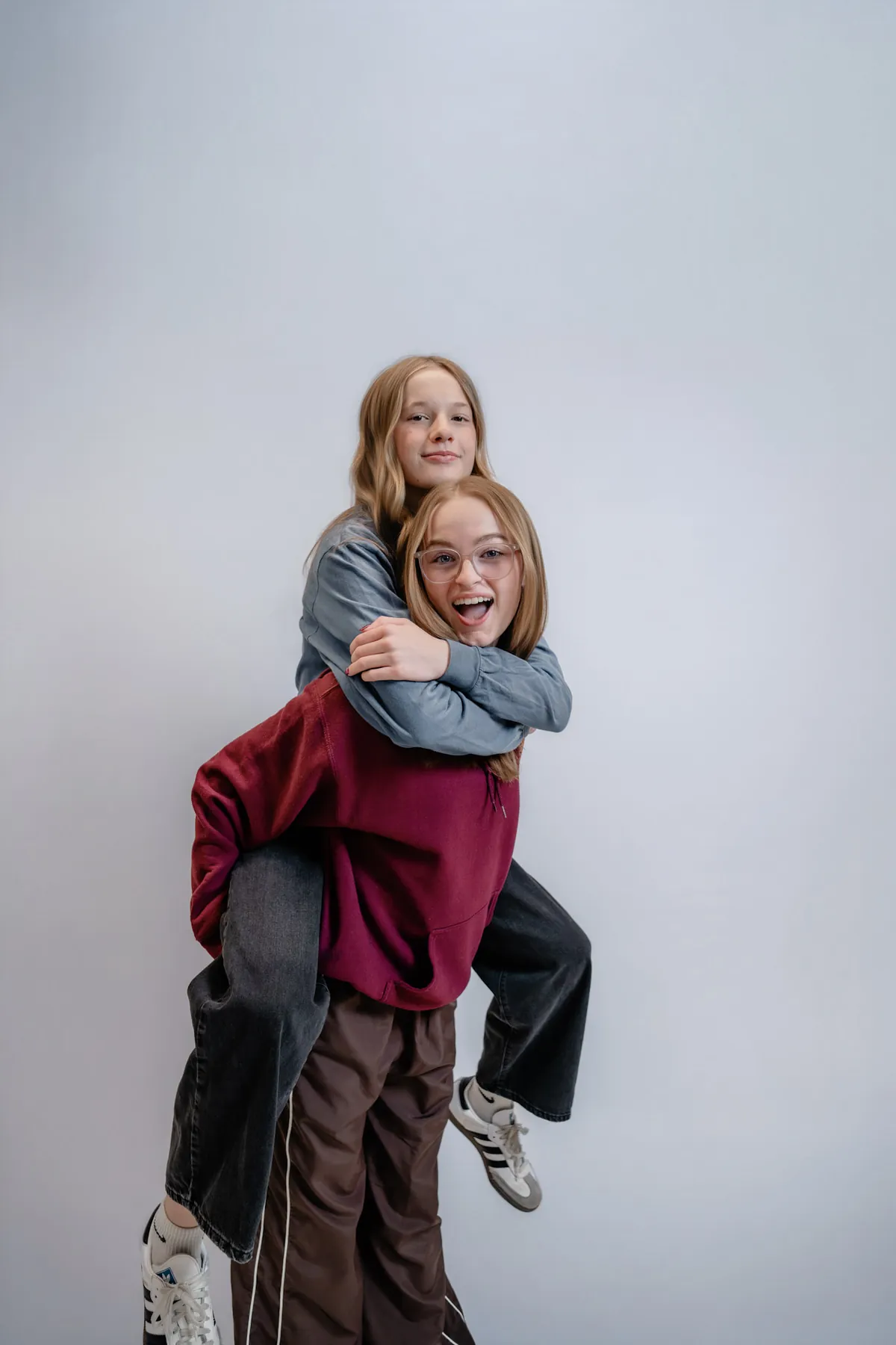 Syd Patzwald and a friend cracking up mid-piggyback in the studio