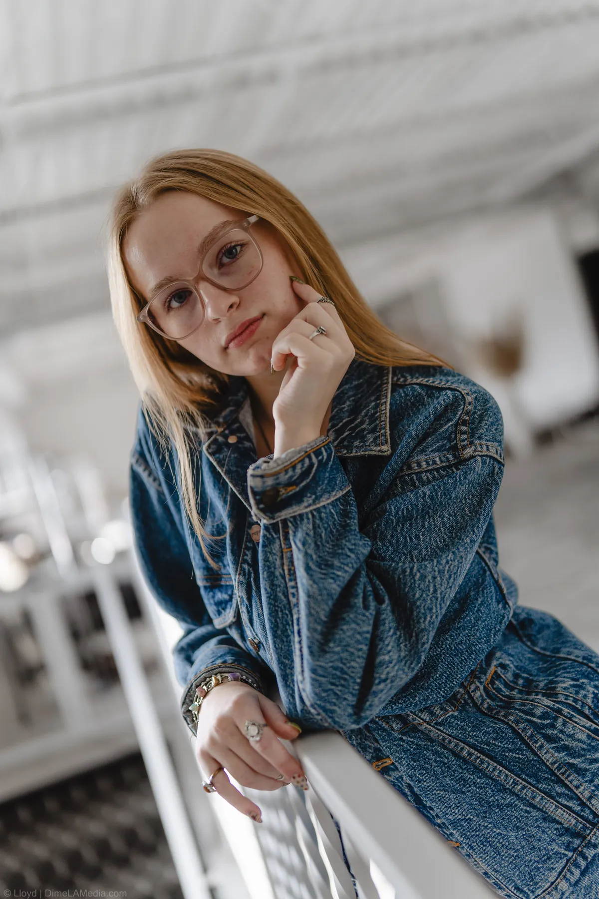 Syd Patzwald resting her chin on her hand at a studio staircase railing
