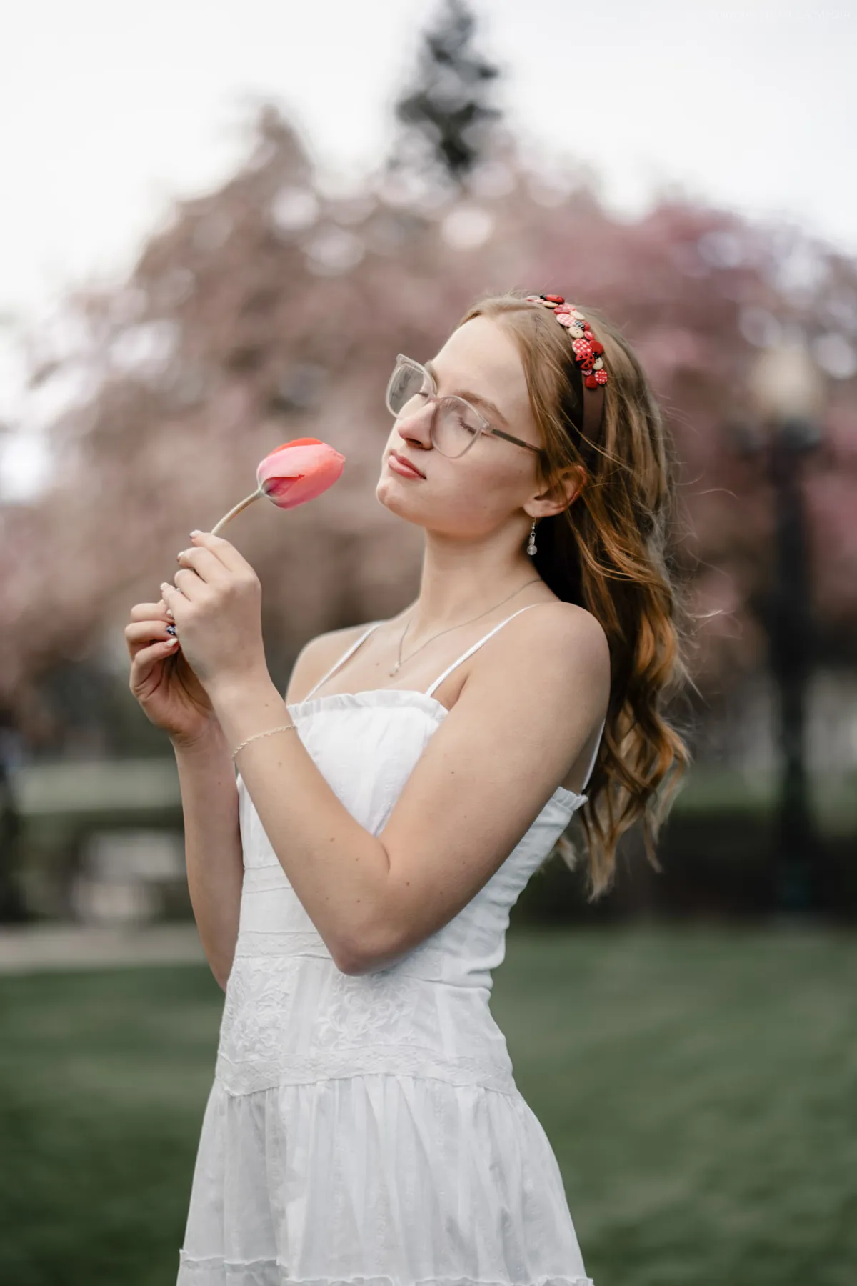 Syd Patzwald holding a tulip in a white dress at golden hour