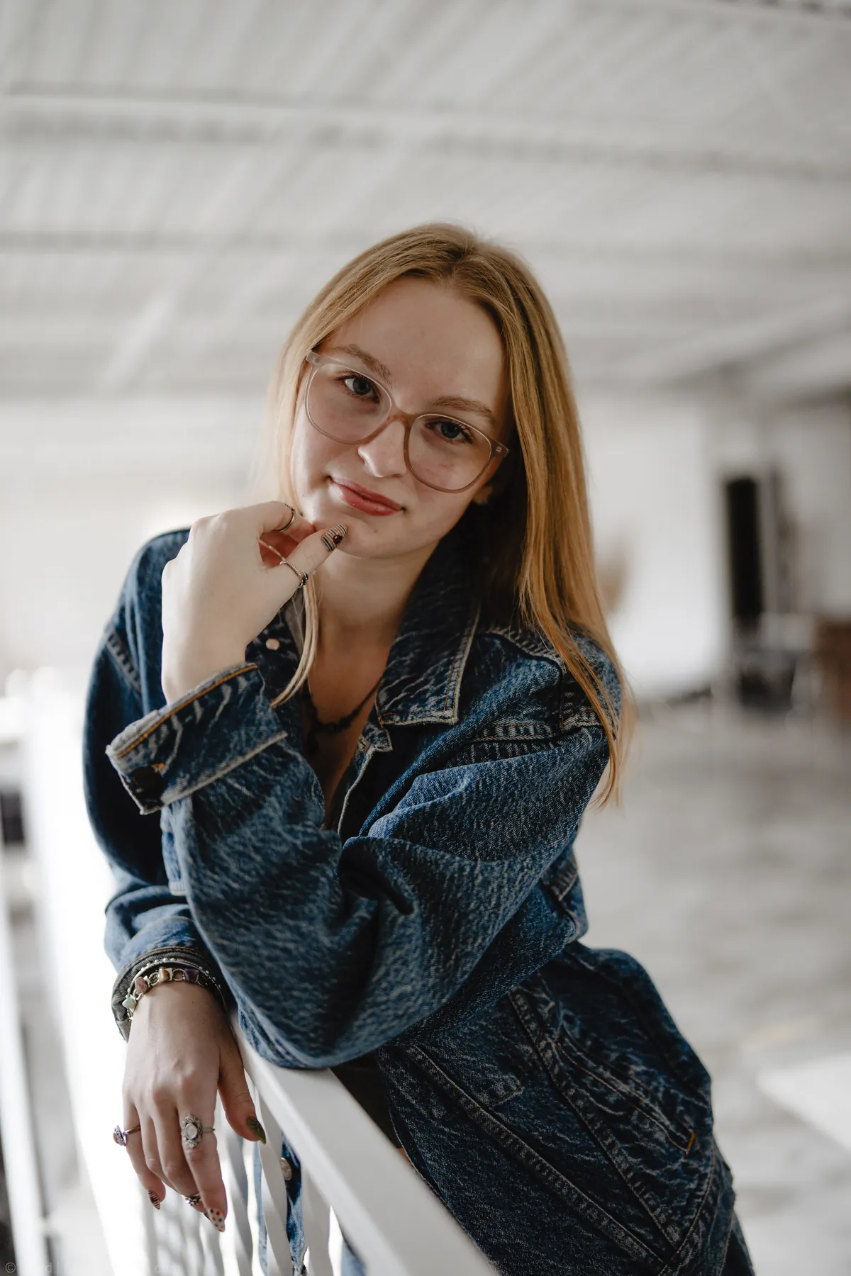 Syd Patzwald resting her chin on her hand, studio staircase portrait
