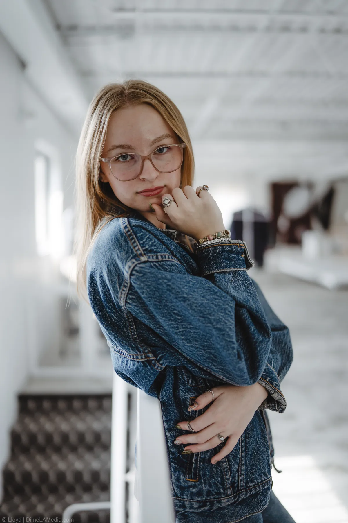 Syd Patzwald with arms crossed leaning on a studio staircase railing