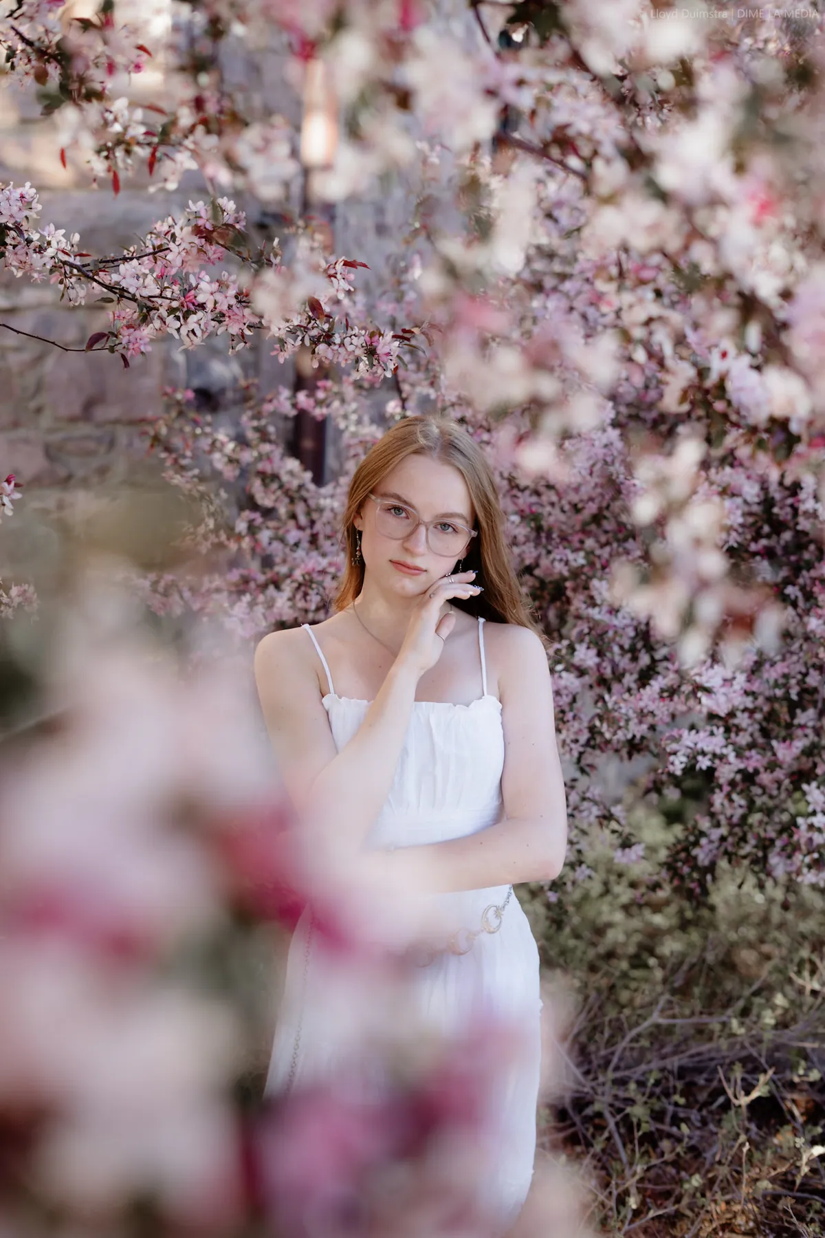 Soft-focus crabapple blossoms framing Syd Patzwald in a white dress