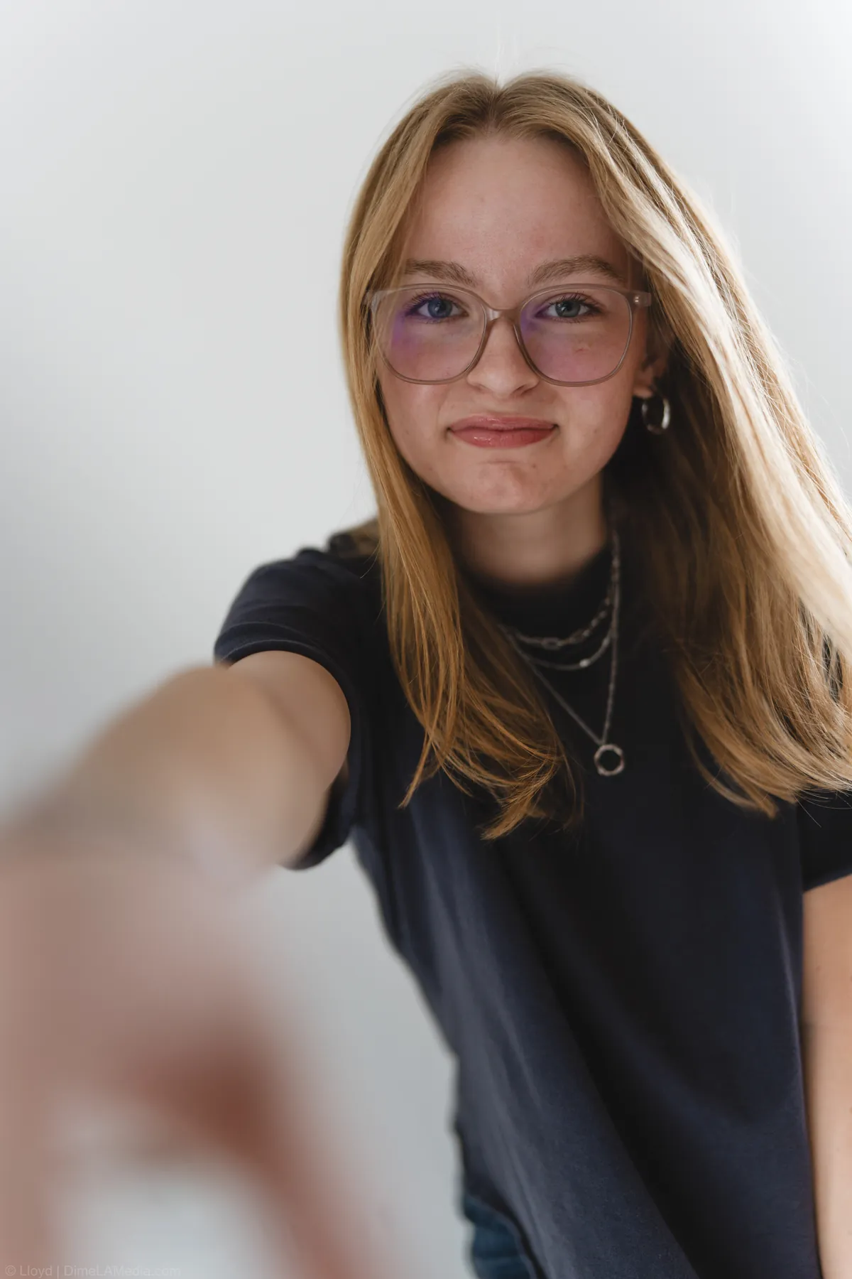 Candid portrait of Syd Patzwald reaching toward the camera in a black t-shirt, studio session