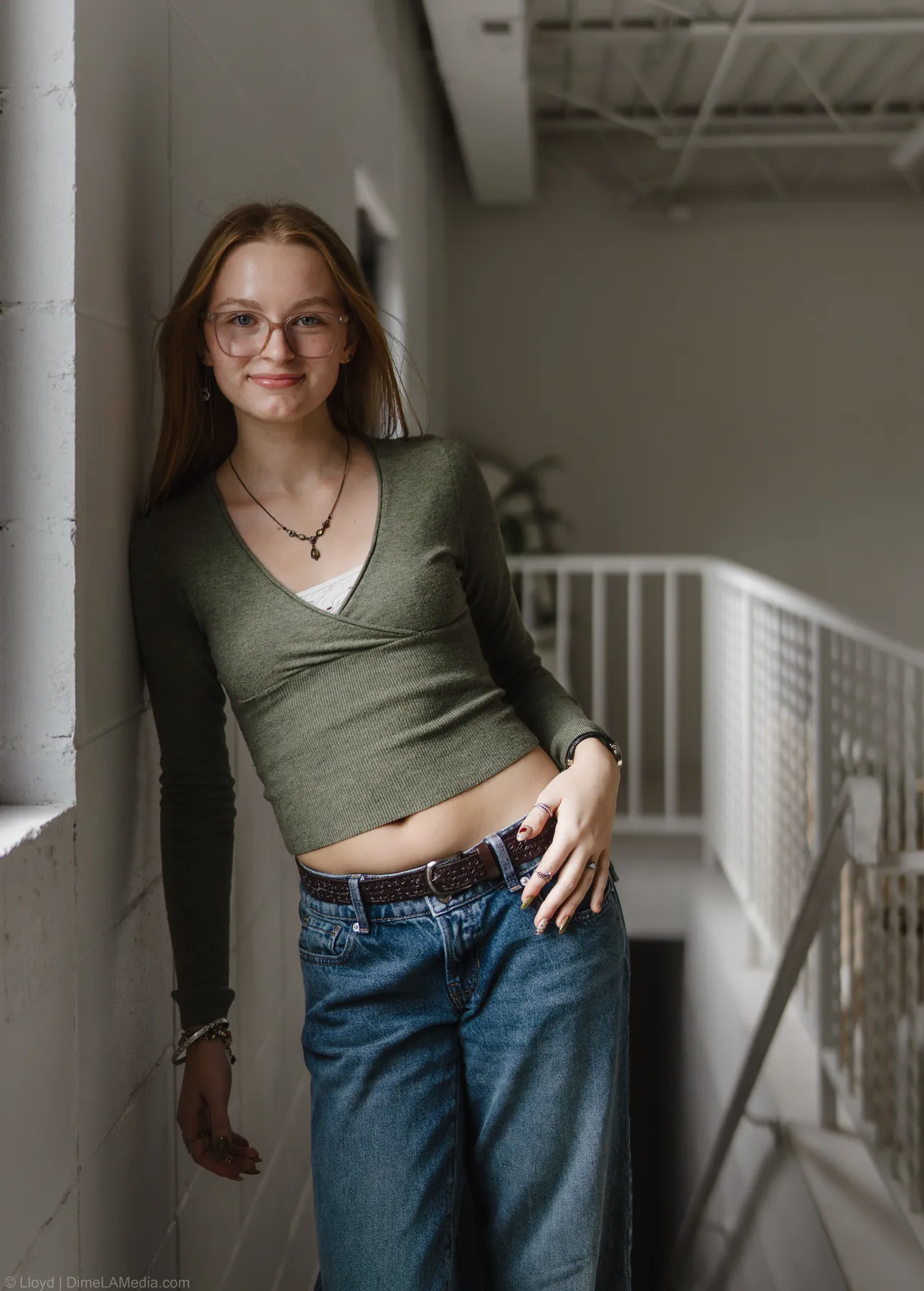 Full length studio portrait of Syd Patzwald leaning against a wall near a staircase