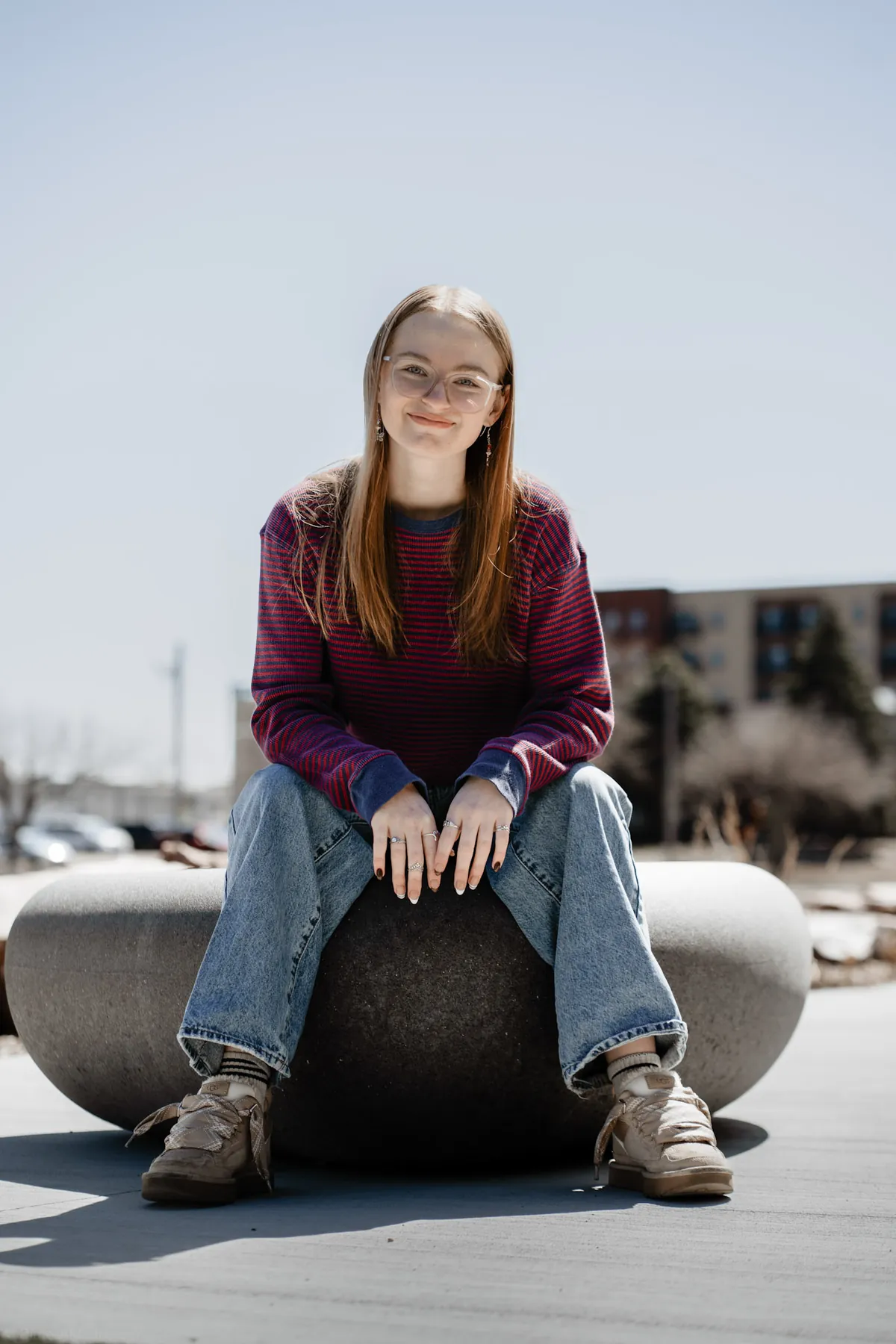 Syd Patzwald perched on a stone sphere in downtown Sioux Falls