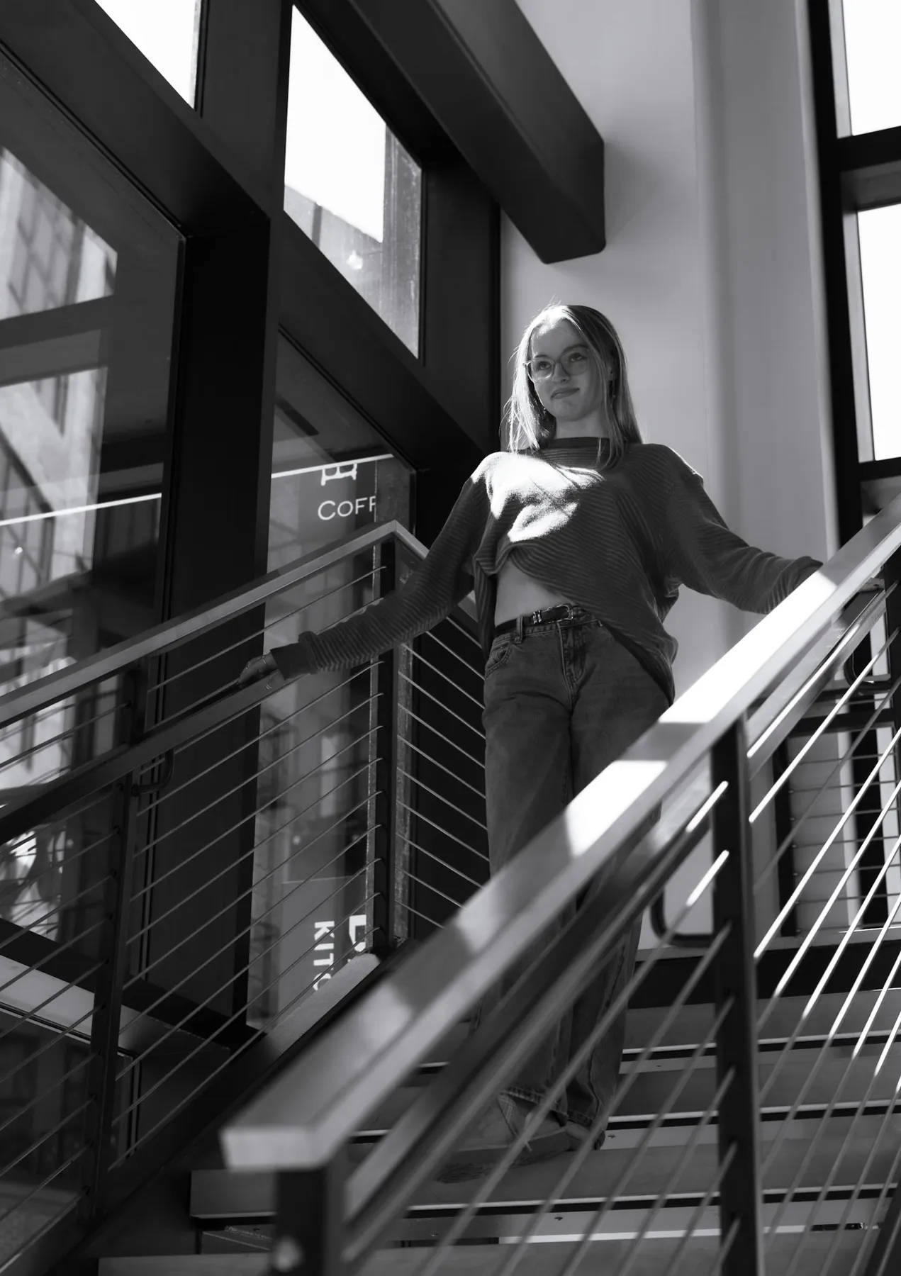 Black and white photo of Syd Patzwald on a modern staircase