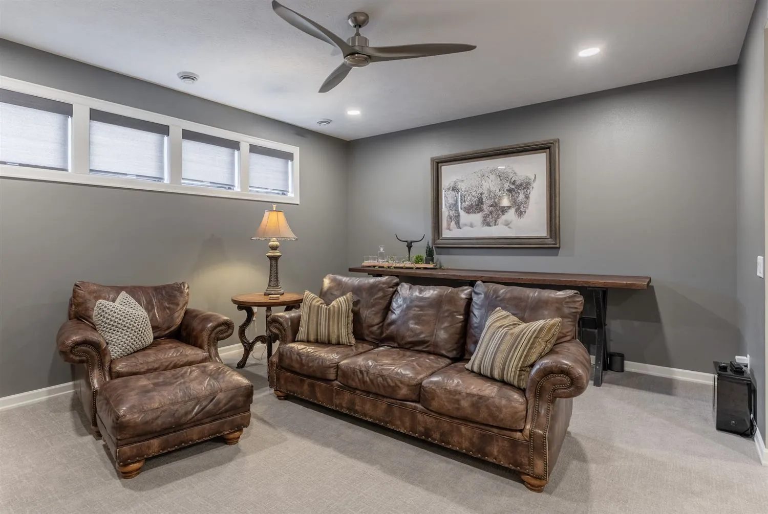 Lower level den with leather seating and bison art, real estate photography Sioux Falls SD