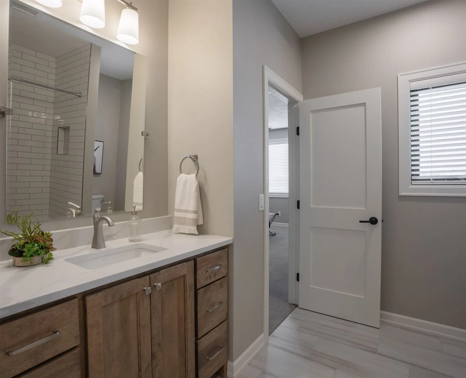 Vanity with wood cabinetry and walk-in closet beyond, real estate photography Sioux Falls SD