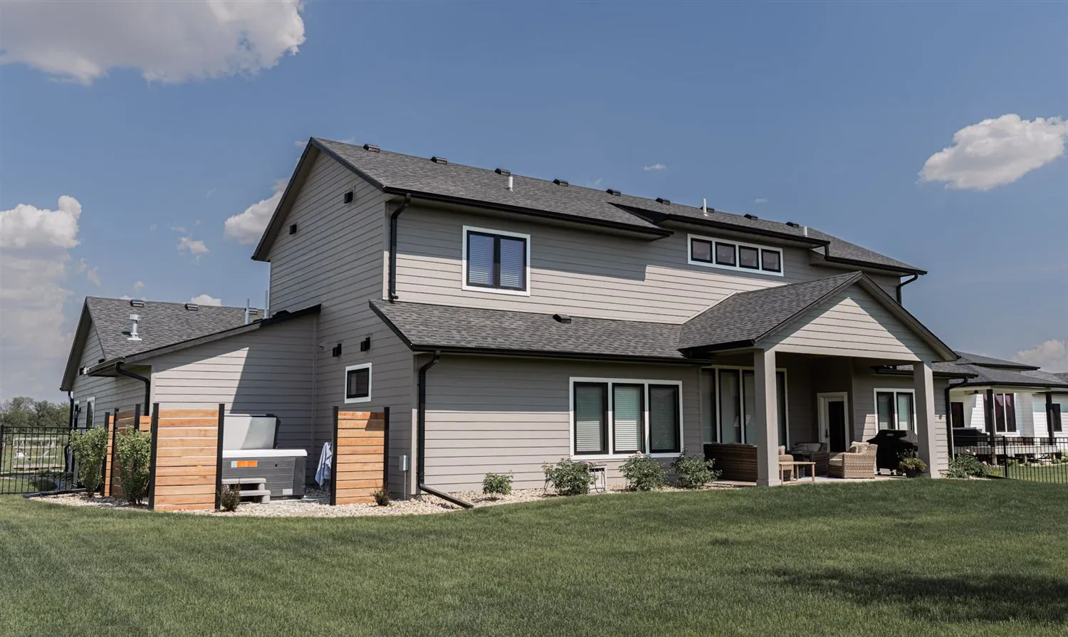 Rear exterior of a modern two-story home with covered patio, real estate photography Sioux Falls SD