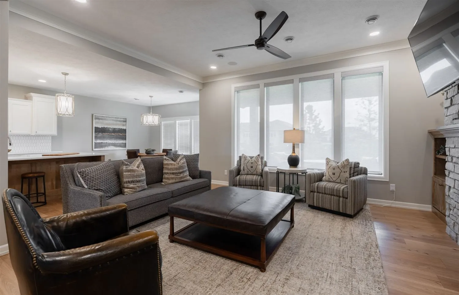 Open great room with stone fireplace and wall of windows, real estate photography Sioux Falls SD