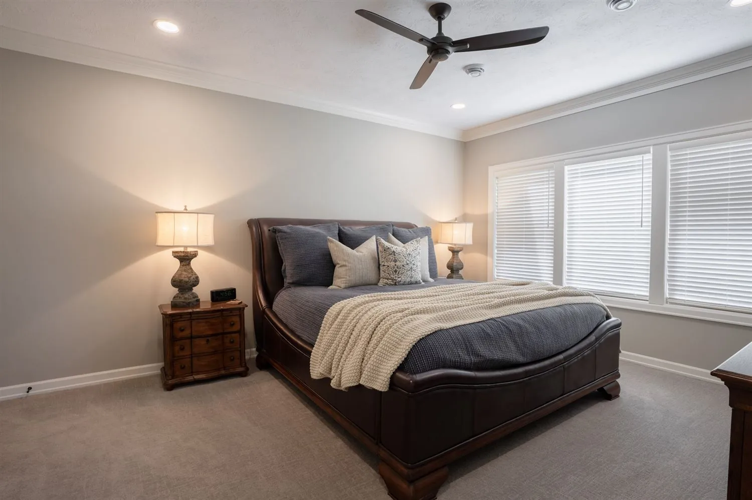 Primary bedroom with upholstered bed and plantation shutters, real estate photography Sioux Falls SD