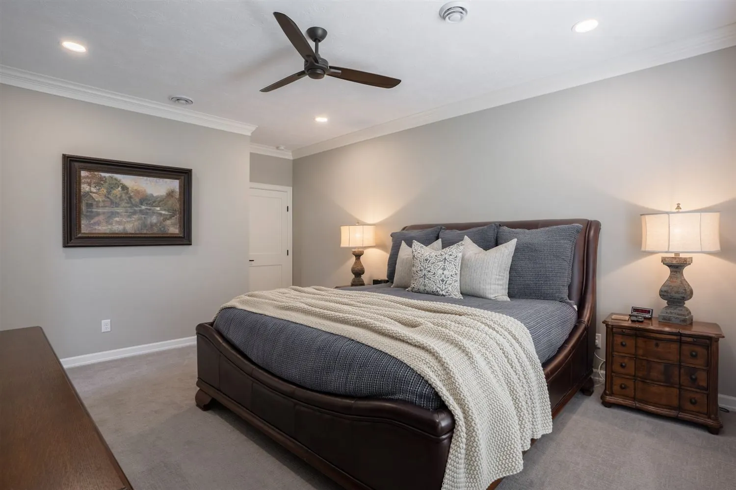 Primary bedroom with framed art and ceiling fan, real estate photography Sioux Falls SD