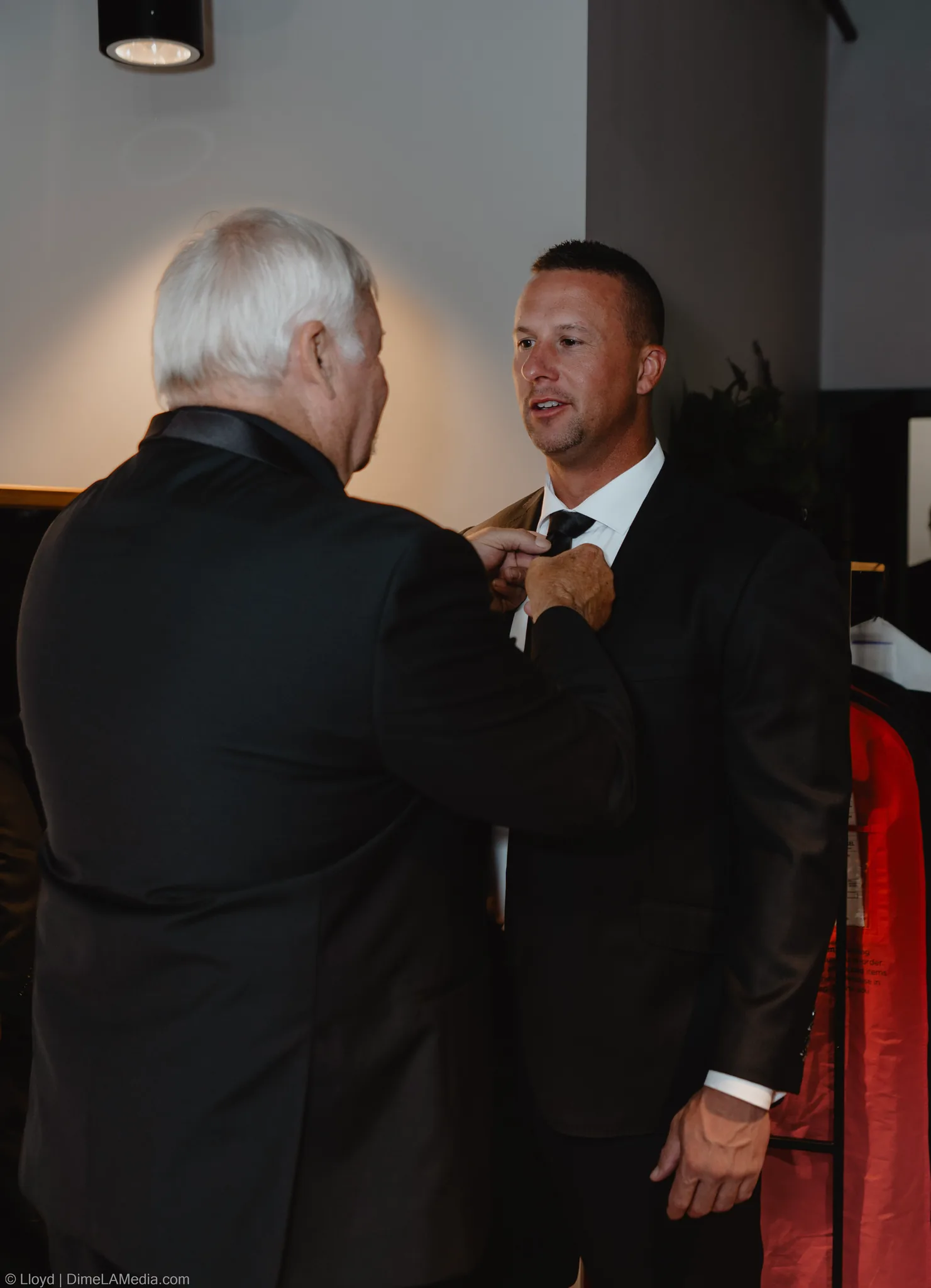 Older man helping the groom with his collar before the ceremony