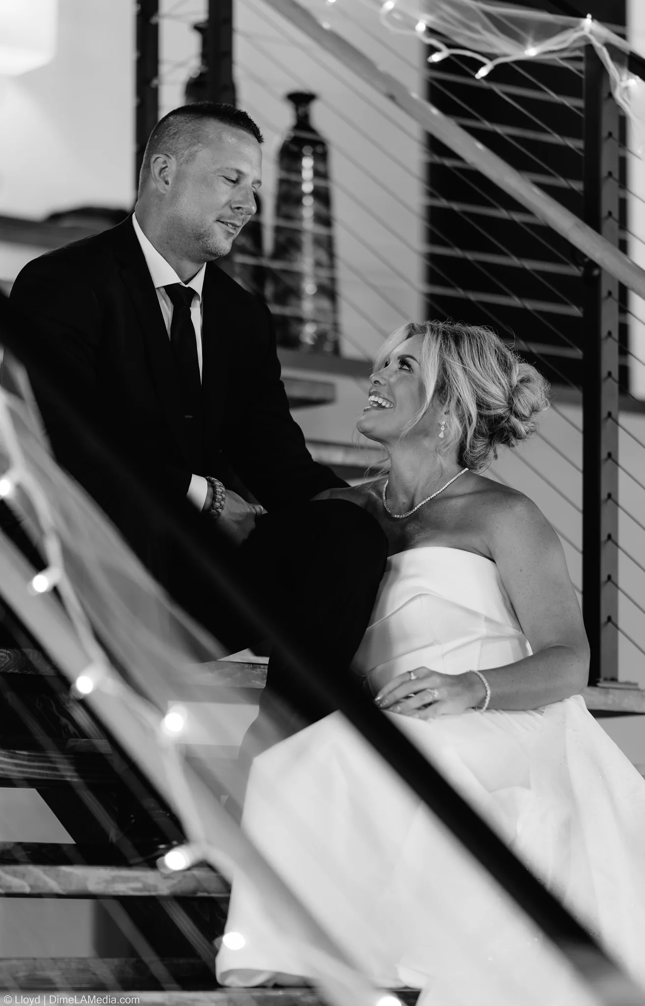 Black and white of the bride and groom laughing together on a staircase