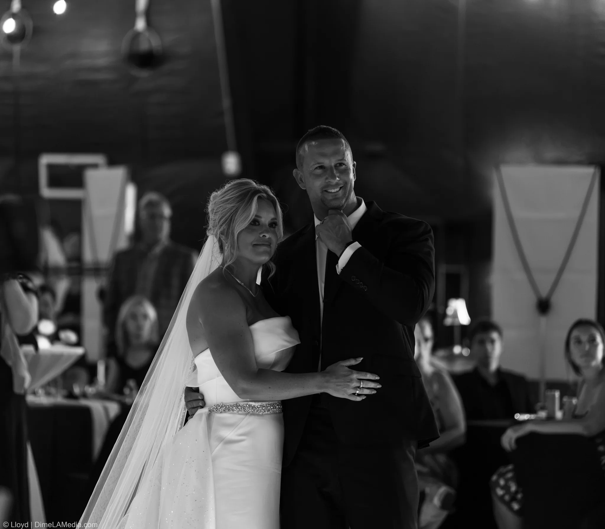 Black and white of the bride and groom close together, guests in the background, Sioux Falls SD