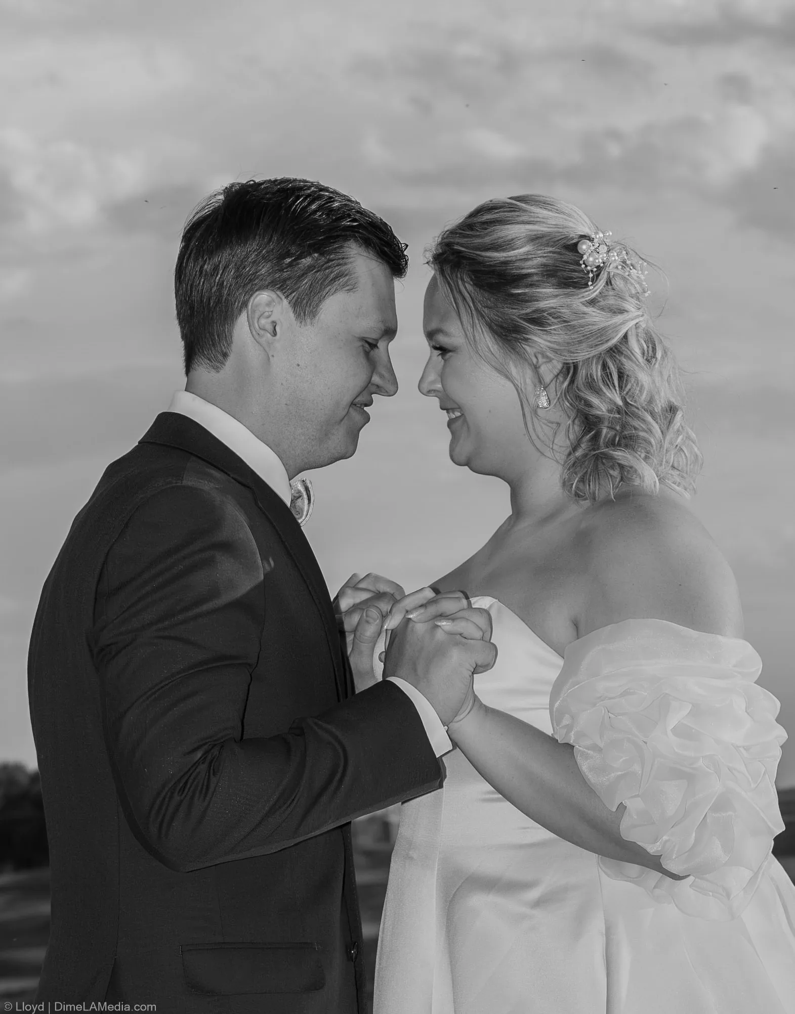 Black and white close portrait of a bride and groom nose to nose at the end of the night
