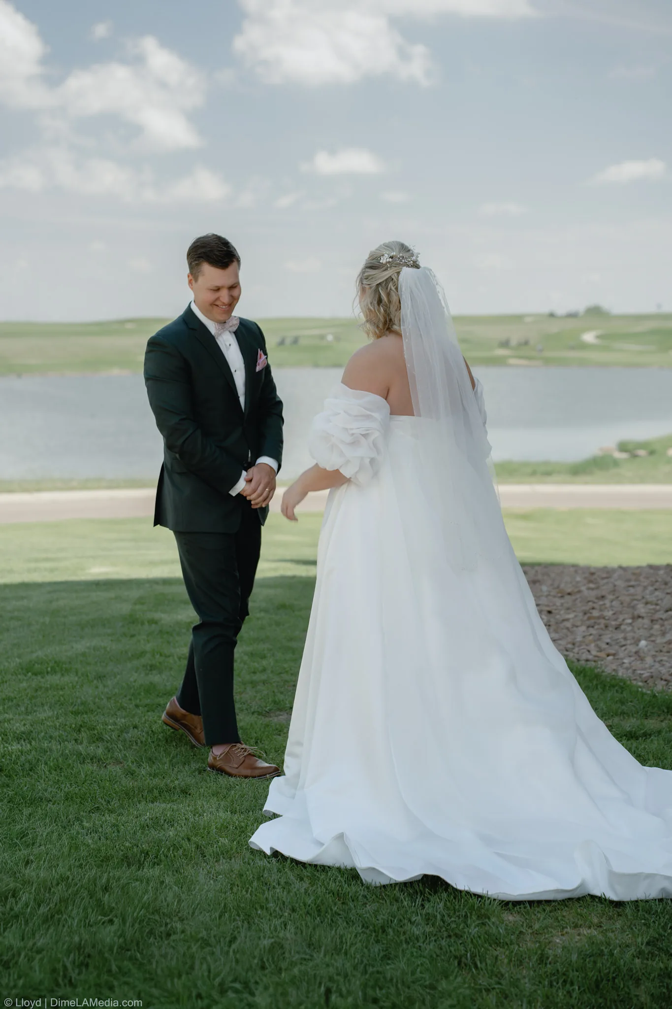 Groom taking in his bride's dress during the first look on the lawn, Sioux Falls SD