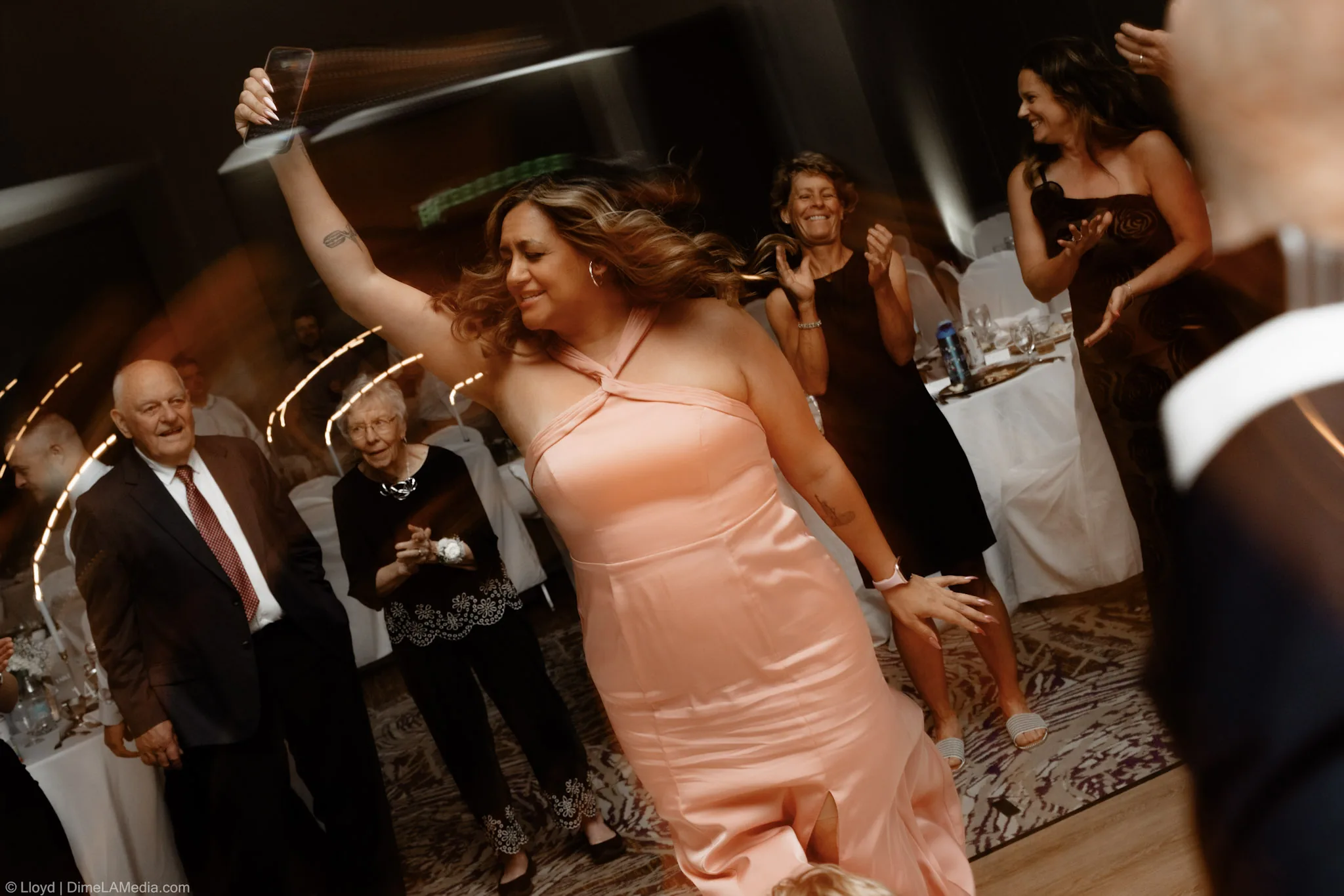 Guest raising a drink in the air on the dance floor at a South Dakota wedding reception
