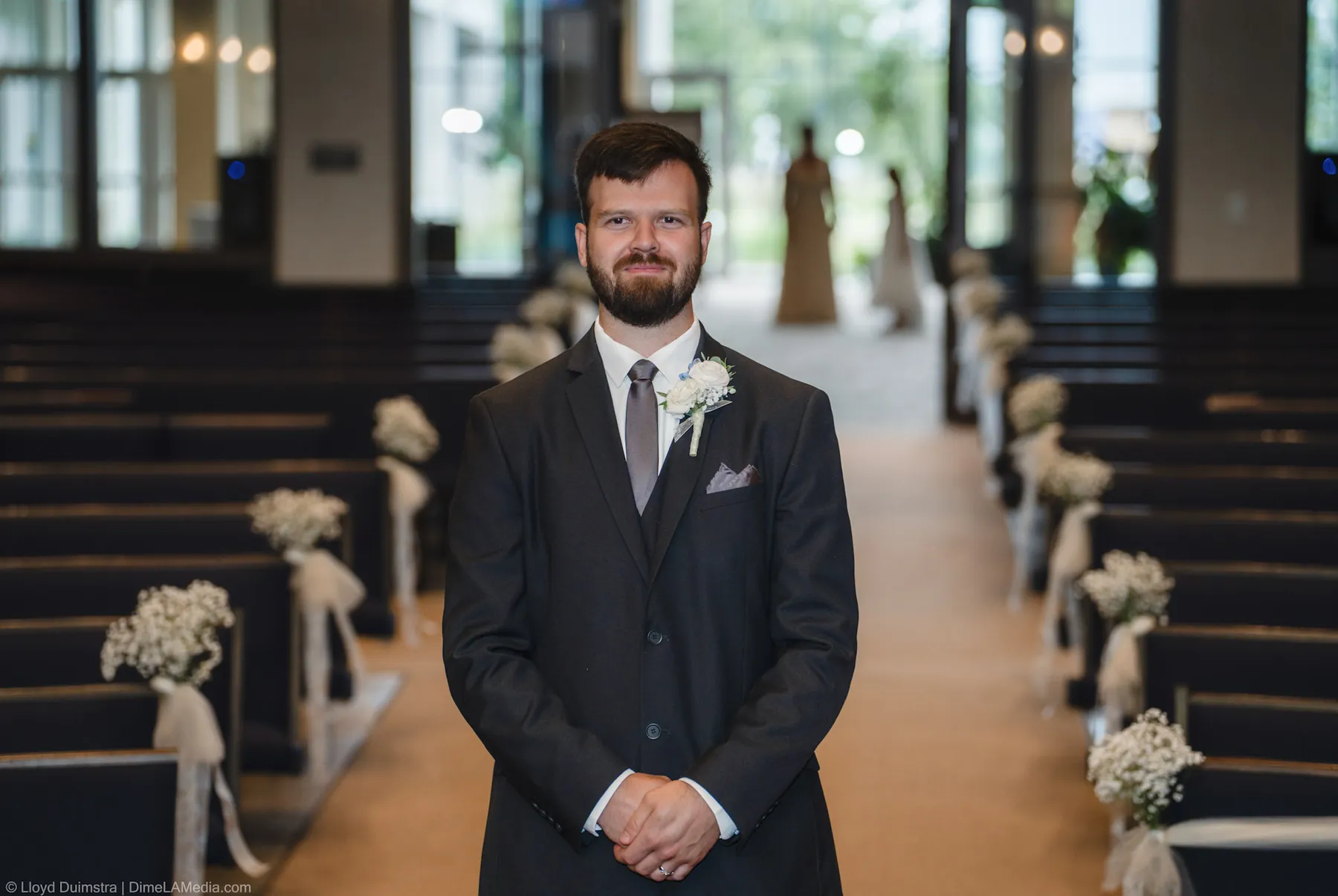 Groom waiting at the end of the aisle in the sanctuary