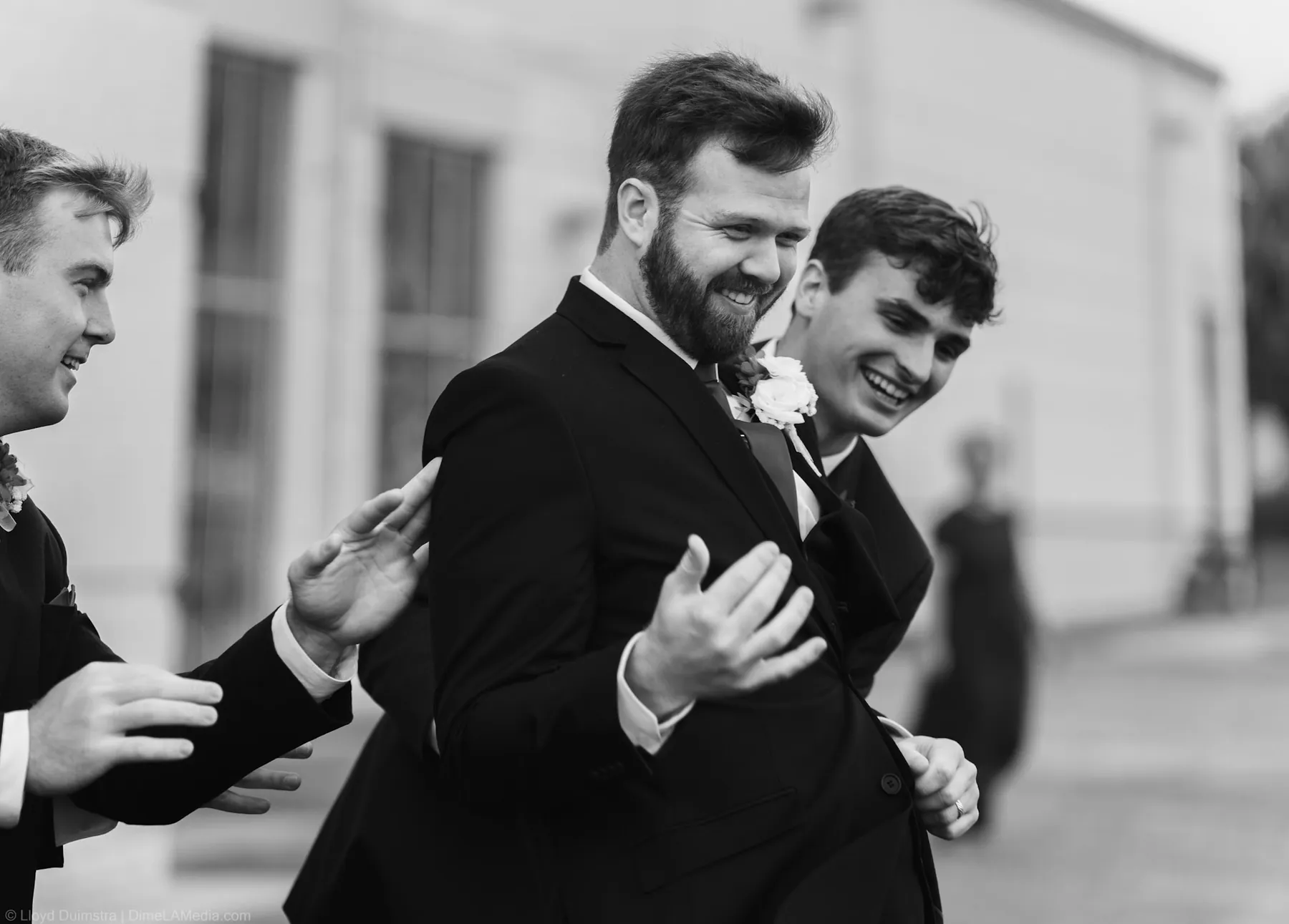 Groom laughing with the groomsmen in black and white